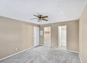 Thumbnail 3 of 17 - Empty room with a ceiling fan and carpeted floor.
