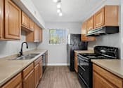 Thumbnail 1 of 24 - A kitchen with wooden cabinets and black appliances.
