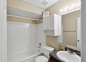 Thumbnail 16 of 17 - A bathroom with a white tub, toilet, and sink.