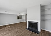Thumbnail 12 of 24 - A modern living room with a fireplace and wooden flooring.