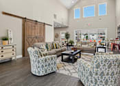 Thumbnail 2 of 39 - Community room with barn doors and patterned furniture at The Lory of Greenway Village Apartments, Kentucky, KY 42001