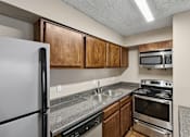 Thumbnail 10 of 17 - A kitchen with a refrigerator, oven, and microwave.