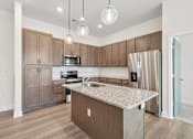 Thumbnail 14 of 28 - A kitchen with brown cabinets and a granite countertop.at The Parker Leland, Leland, 28451  