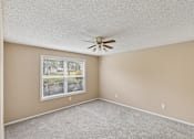 Thumbnail 7 of 17 - A room with a ceiling fan and a window.