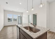 Thumbnail 18 of 28 - A kitchen with a granite countertop and a stainless steel sink.at The Parker Leland, Leland, NC  