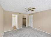 Thumbnail 11 of 17 - A room with a ceiling fan and carpeted floor.