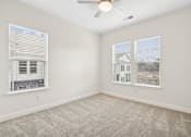Thumbnail 17 of 28 - A room with a ceiling fan and two windows with blinds.at The Parker Leland, Leland, NC 28451  