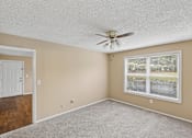 Thumbnail 5 of 17 - A room with a ceiling fan and a window.