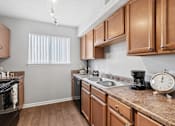 Thumbnail 10 of 24 - A kitchen with wooden cabinets and a granite countertop.