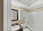 Thumbnail 17 of 17 - A bathroom with a white toilet, sink, and bathtub.