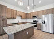 Thumbnail 24 of 28 - A kitchen with wooden cabinets and a granite countertop.at The Parker Leland, North Carolina  