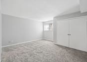 Thumbnail 20 of 24 - A room with a carpeted floor and a white door.
