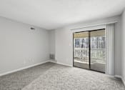 Thumbnail 5 of 24 - A room with a sliding glass door leading to a balcony.