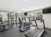 Thumbnail 3 of 24 - A spacious gym with treadmills, weights, and exercise equipment.