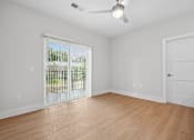 Thumbnail 39 of 51 - Empty bedroom with vinyl wood flooring and sliding glass door at The Palms Apartments, Charleston, SC
