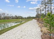 Thumbnail 13 of 28 - A gravel path runs alongside a body of water.at The Parker Leland, Leland, NC  
