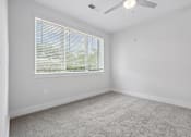 Thumbnail 34 of 51 - Spacious bedroom with large window and carpet flooring at The Palms Apartments, South Carolina, 29407