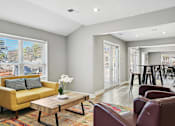 Thumbnail 7 of 26 - Living room with a yellow couch and a coffee table   and a kitchen  at Emerald Bay, North Carolina