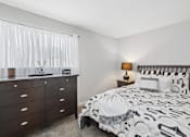 Thumbnail 22 of 24 - A bedroom with a bed, nightstand, and dresser.