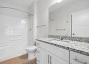 Thumbnail 45 of 51 - Bathroom with granite countertop and white cabinetry at The Palms Apartments, Charleston, SC