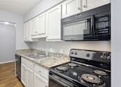 Thumbnail 5 of 15 - Kitchen with white cabinets and black appliances and a sink  at Governors House, Huntsville, Alabama
