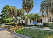 Thumbnail 11 of 51 - Property information center with palm trees and flower beds at The Palms Apartments, Charleston