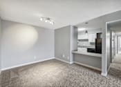 Thumbnail 11 of 15 - the living room and kitchen of an apartment with gray walls and carpet  at Governors House, Huntsville