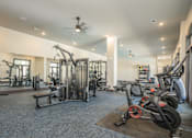 Thumbnail 32 of 37 - A gym with a variety of equipment including treadmills, weights, and a bench at The Ashton at East Park Apartments, Kennesaw, Georgia