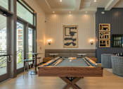 Thumbnail 35 of 37 - A pool table is in the middle of a room with a fireplace and a TV at The Ashton at East Park Apartments, Georgia, 30144