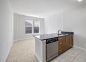 Thumbnail 32 of 64 - A kitchen with a black counter top and stainless steel appliances.