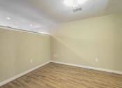 Thumbnail 9 of 50 - a empty room with wood flooring and white walls