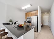 Thumbnail 10 of 64 - A kitchen with a black counter top and stainless steel appliances.