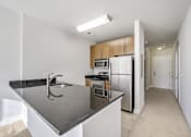 Thumbnail 27 of 64 - A kitchen with a black counter top and stainless steel appliances.