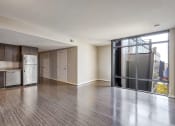 Thumbnail 22 of 50 - an empty living room with a kitchen and a glass door
