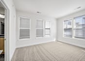 Thumbnail 20 of 64 - A room with a carpeted floor and three windows.