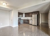 Thumbnail 21 of 50 - an empty kitchen with stainless steel appliances and wooden floors