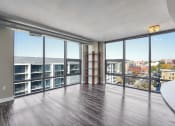 Thumbnail 16 of 50 - an open living room with windows and a view of a city