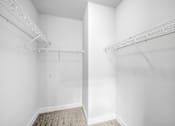 Thumbnail 25 of 64 - Empty white room with a carpeted floor and two white shelves.