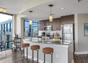 Thumbnail 12 of 50 - a kitchen with a large island with four stools