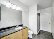 Thumbnail 26 of 64 - A bathroom with a sink, mirror, toilet and shower.
