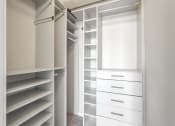 Thumbnail 18 of 50 - a walk in closet with white shelves and a window