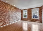 Thumbnail 7 of 50 - an empty room with a brick wall and wood floors