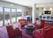 Thumbnail 38 of 50 - a living room with red chairs and a bar and a balcony