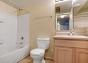 Thumbnail 8 of 17 - A white toilet sits next to a bathtub in a bathroom.