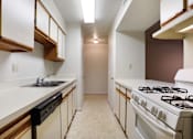 Thumbnail 5 of 17 - A kitchen with white cabinets and a white stove top oven.