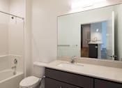 Thumbnail 21 of 37 - a bathroom with a shower sink and toilet and a mirror