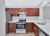 Thumbnail 6 of 25 - a kitchen with white countertops and dark wood cabinets
