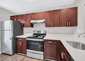 Thumbnail 5 of 25 - a kitchen with dark wood cabinets and white countertops