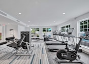 Thumbnail 18 of 32 - a gym with treadmills and other exercise equipment