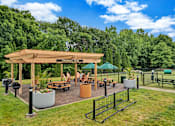 Thumbnail 21 of 32 - a pavilion with a seating area and a dog park in the background